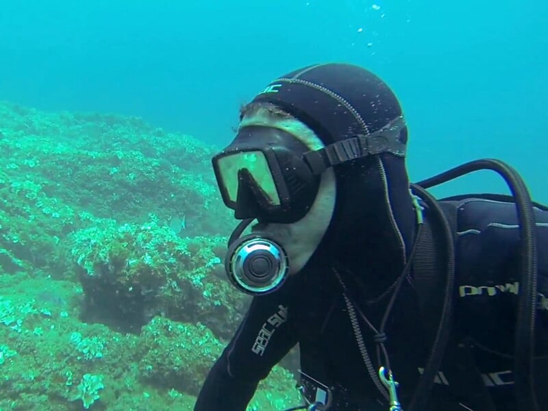 Un plongeur équipé d'un masque et d'un tuba explore les fonds marins rocheux sous l'eau.