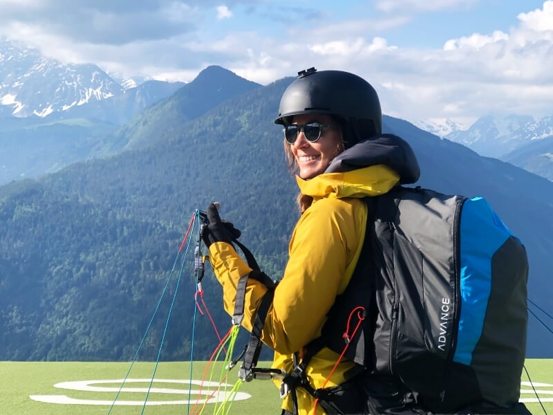 Personne souriante en tenue de parapente avec casque et lunettes, prête à décoller à Chamonix Mont Blanc.