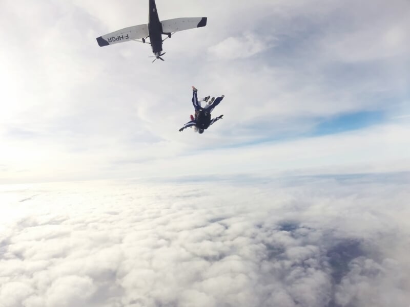 un parachutiste tombe dans un avion au-dessus des nuages blancs