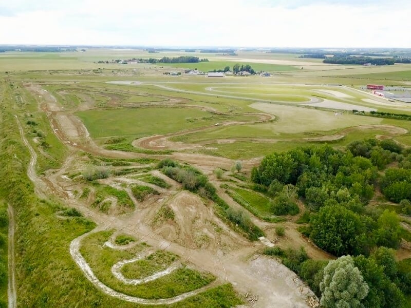Vue aérienne d'un circuit tout-terrain avec pistes sinueuses et zones herbeuses à La Ferté Gaucher.