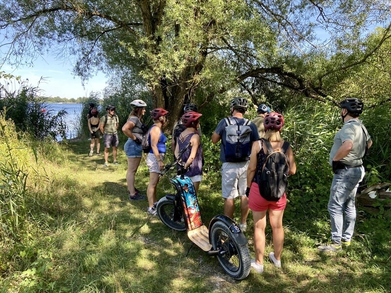 Groupe de personnes faisant une pause à l'ombre lors d'une sortie trottinette électrique