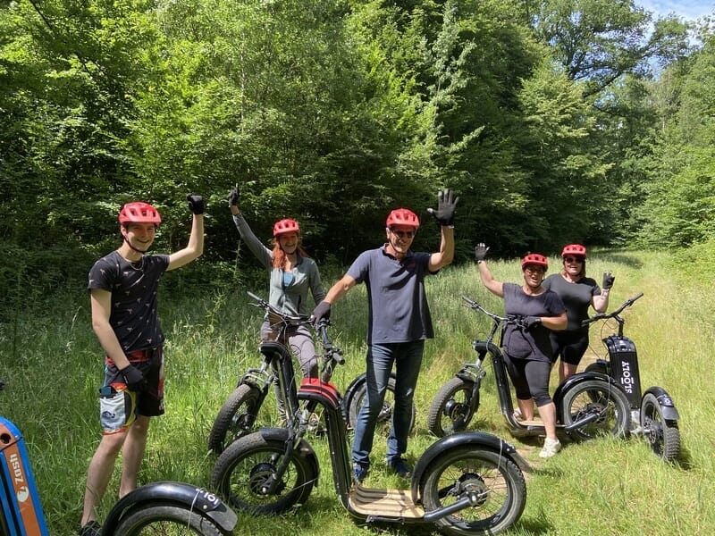 Groupe de personnes dans un près en trottinette électrique