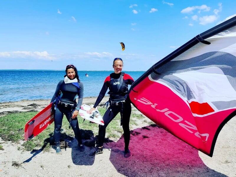 des kitesurfeuses posent sur la plage
