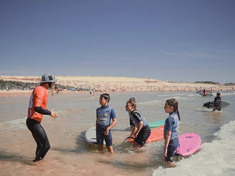 le moniteur de surf donne un cours technique aux enfants