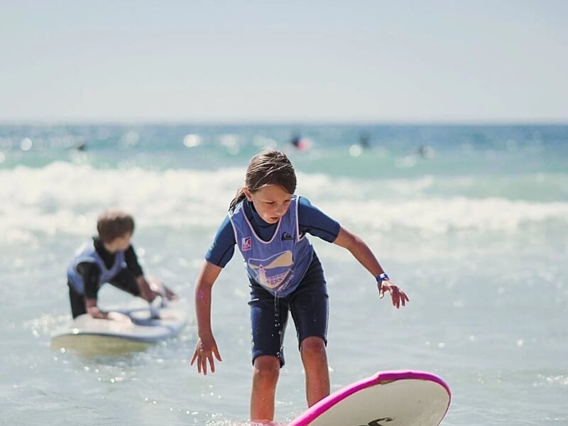 une jeune fille surfe sa première vague