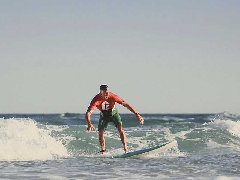 un apprenti surfeur glisse sur ses premières vagues
