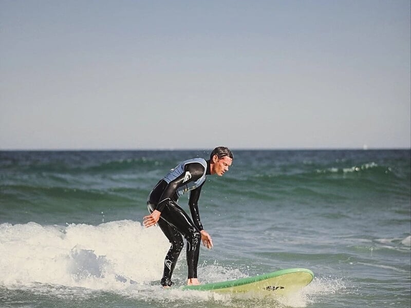 un homme apprend à tenir sur sa planche de surf