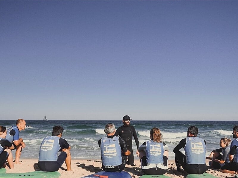 un cours technique de surf collectif sur la plage