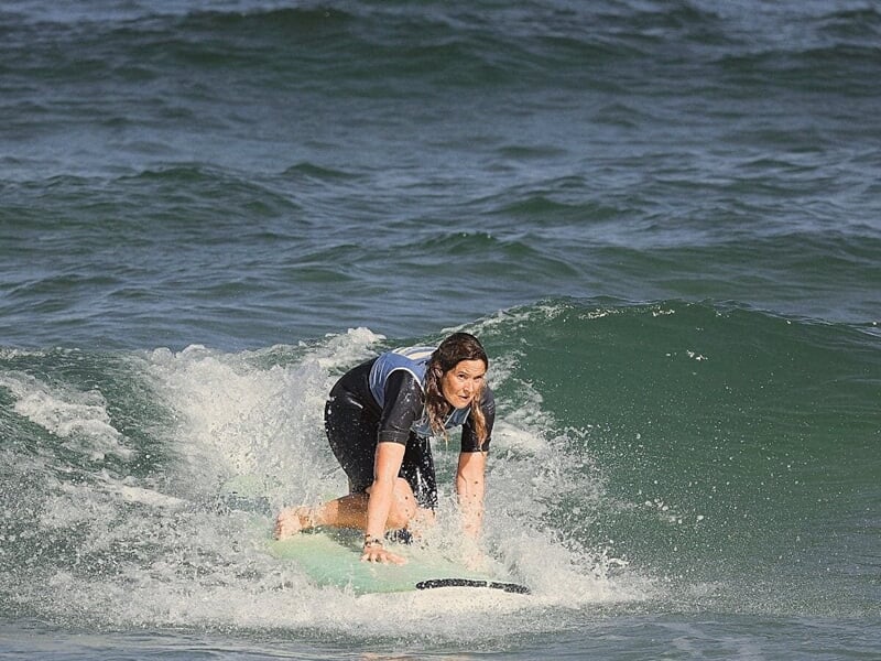 une surfeuse débutante apprend à se redresser sur sa planche