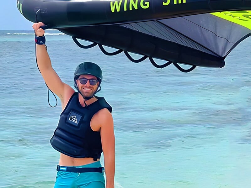 un surfeur wingfoil prend la pose
