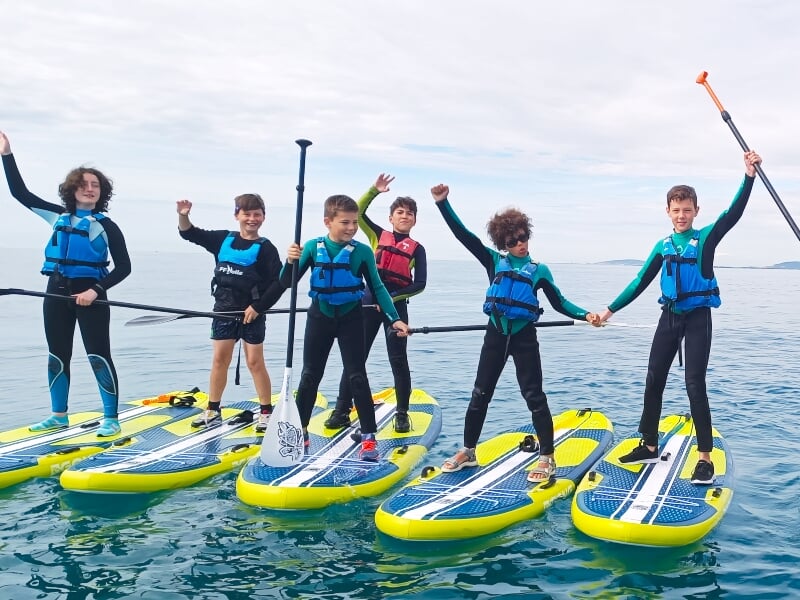 un groupe d'enfants sur des planches de paddle