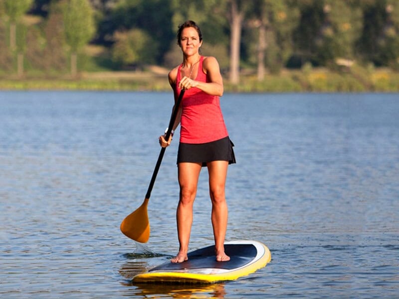 une femme navigue sur le Lac de la Liez debout sur son paddle