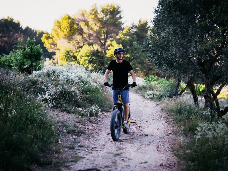 Une personne en trottinette électrique sur un chemin