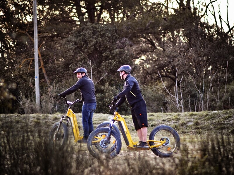 Deux personnes en trotinette électrique dans la campagne