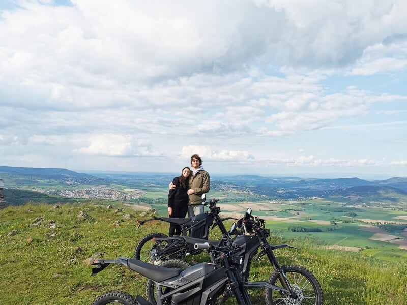 un couple qui pose devant les motos électriques
