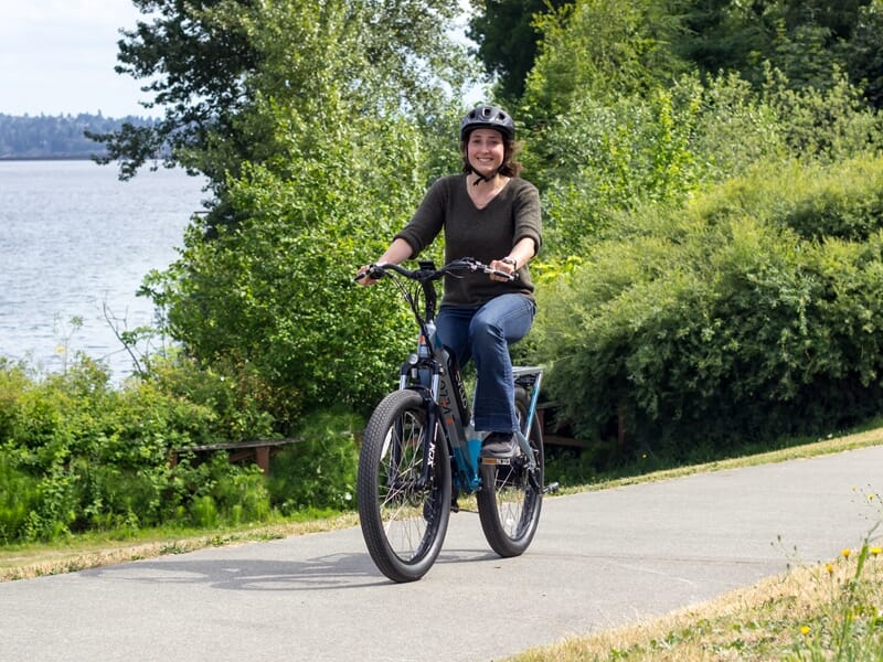 femme sur un vélo életrique près d'un lac