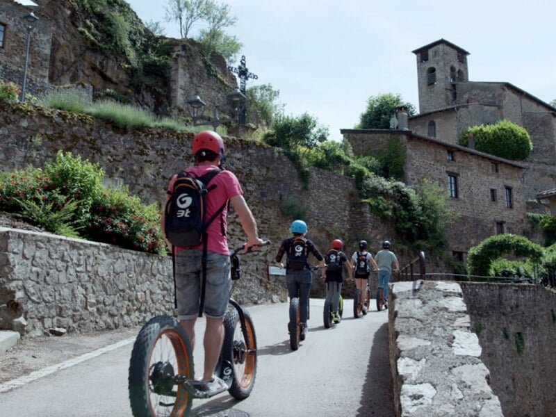 groupe de personnes en trottinette électrique dans village