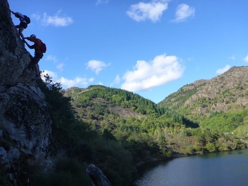 Personnes pratiquant la via ferrata au dessus du lac de Villefort