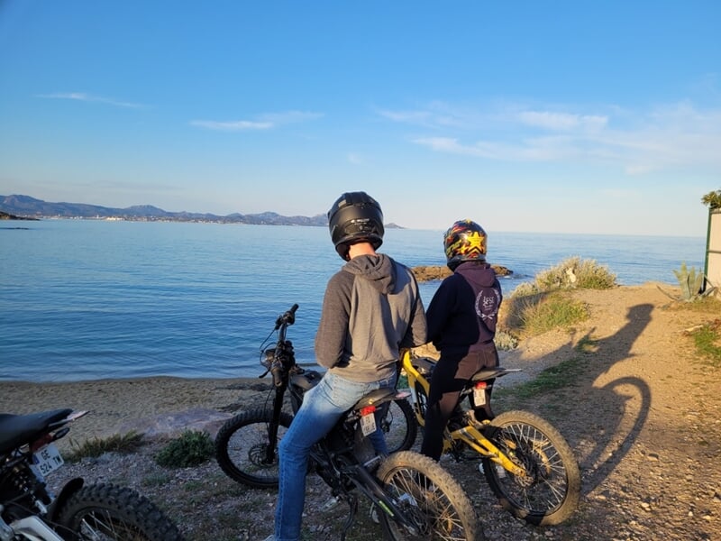 deux personnes en moto regardent la mer