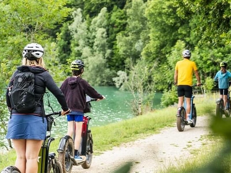 famille en trottinette électrique sur chemin de campagne