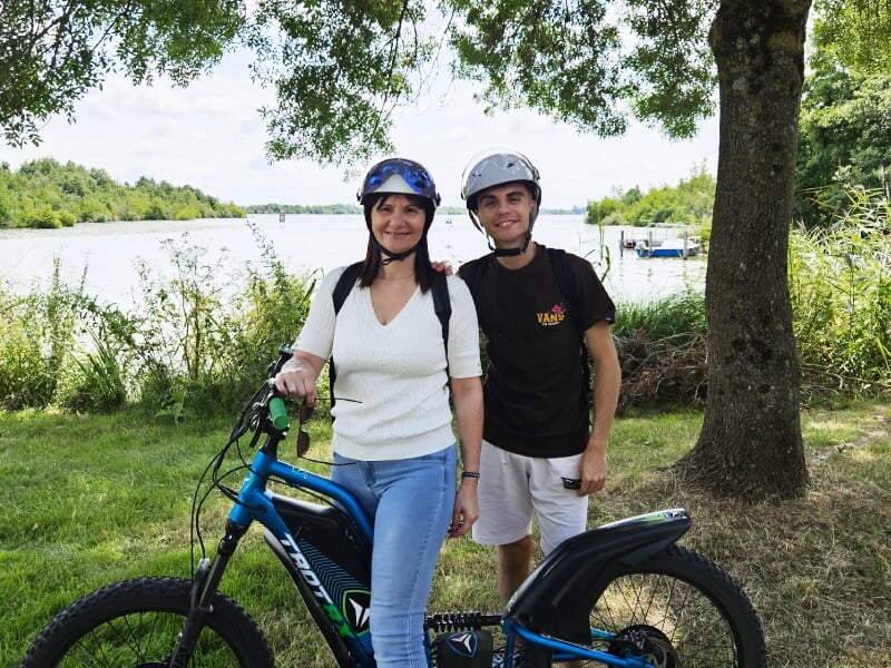 duo de randonneurs à trottinette électrique devant l'étang de bout de bois de saffré