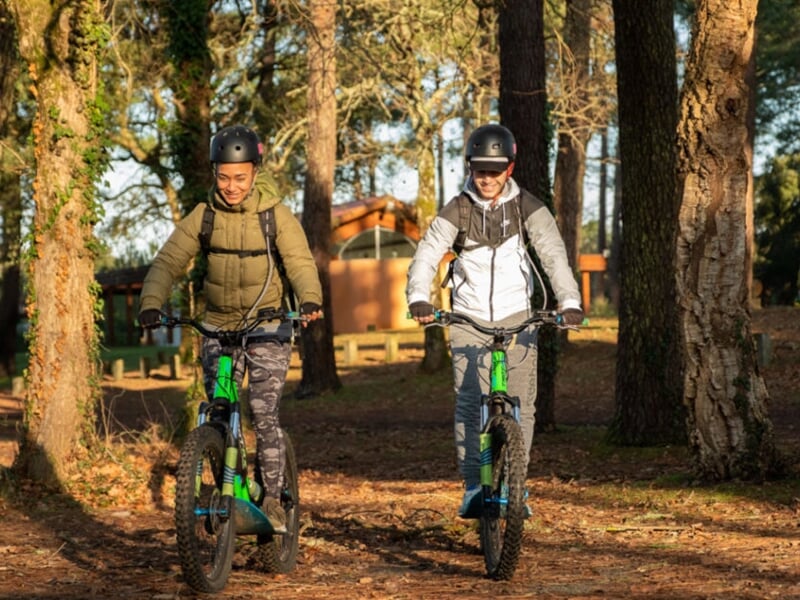 2 personnes en trottinette électrique dans la forêt