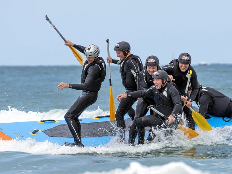 un groupe tente de garder son équilibre en wave rafting
