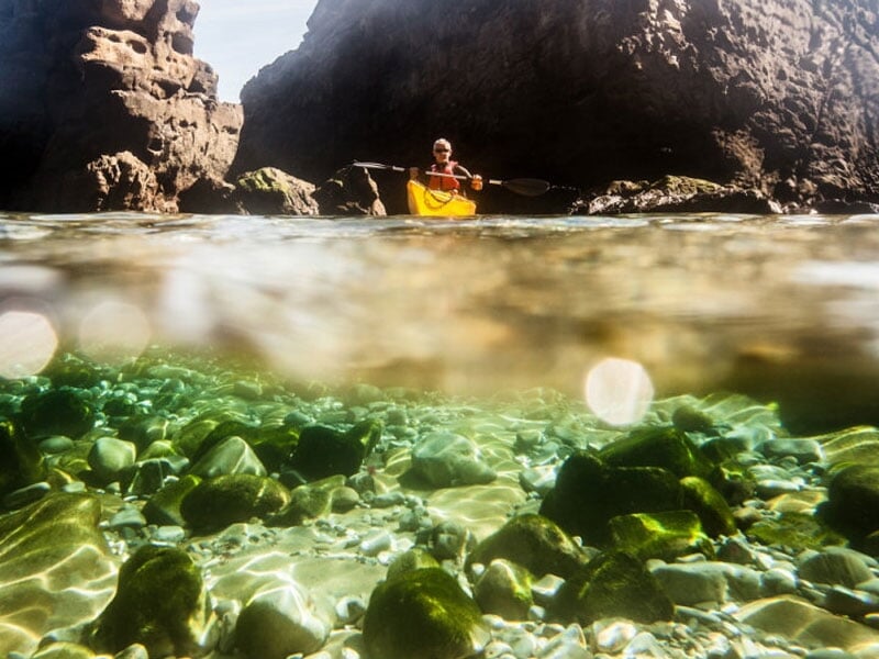 un homme fait une balade en kayak de mer entre les rochers
