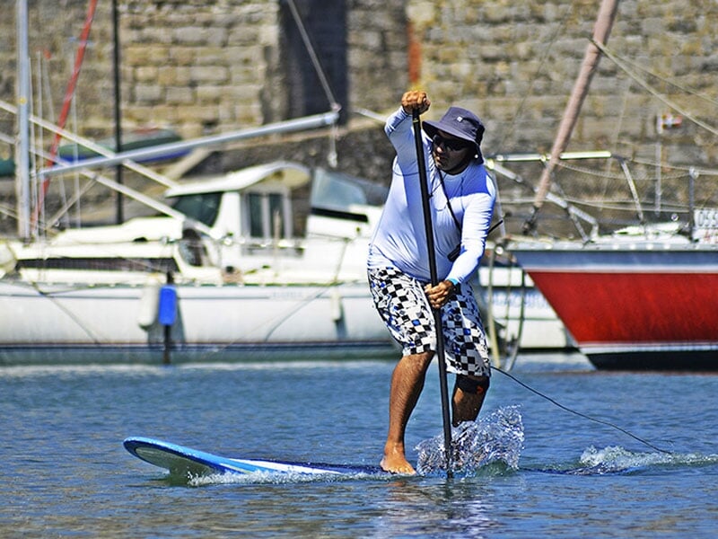 un homme se déplace en paddle avec sa pagaie
