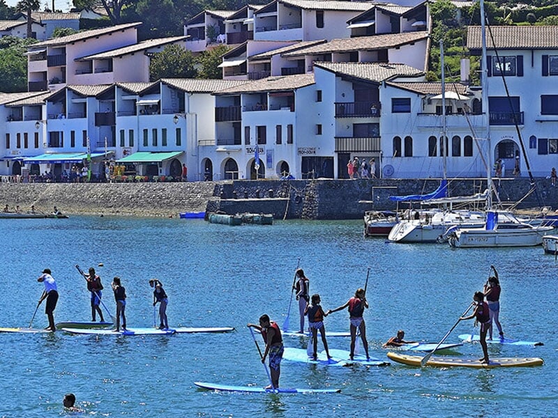 un groupe se balade au large de la plage en paddle