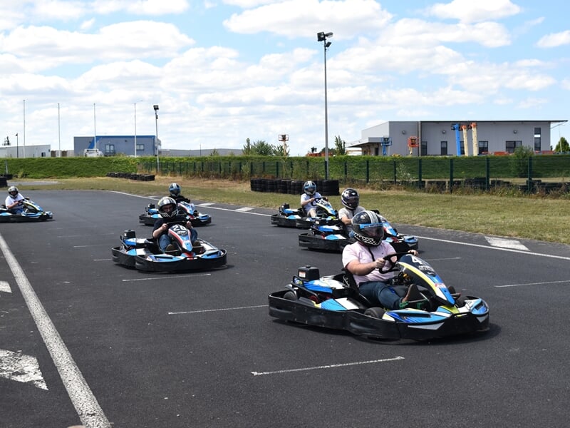 Groupe de personnes au départ pour une course de karting sur le circuit de Caen