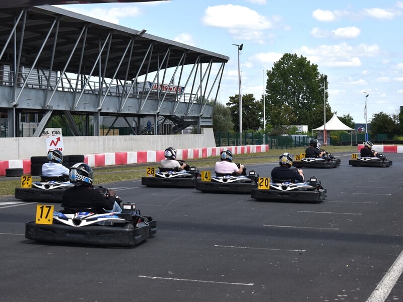 Groupe de personnes en train de faire une course de karting sur circuit