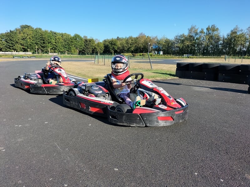 Deux enfants en train de piloter un karting sur un circuit
