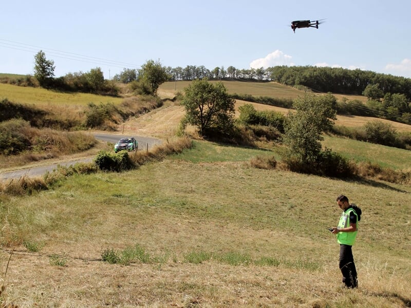 un drone et son pilote survolent une course de rallye