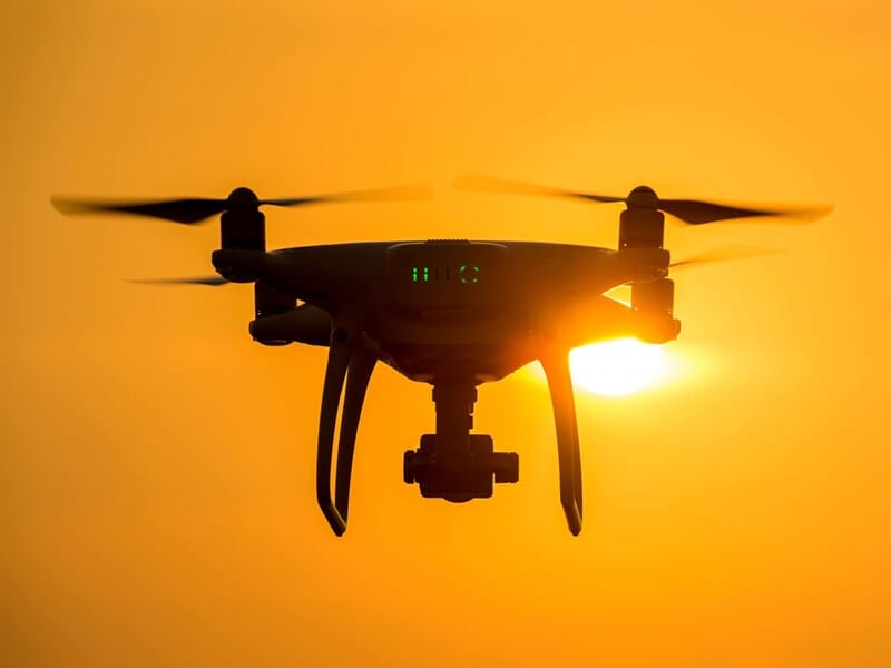 un drone vole au coucher du soleil
