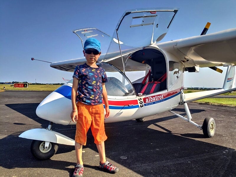 un enfant pose devant l'ULM multiaxes