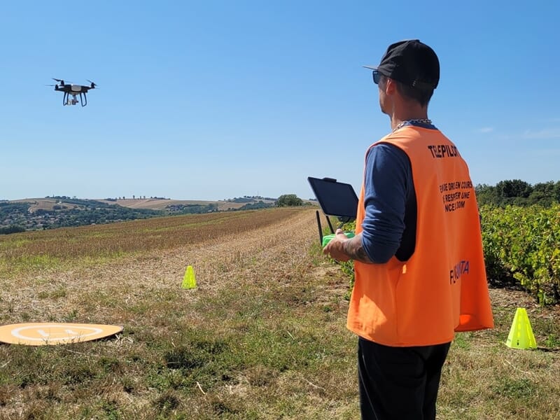 homme pilotant un drone en campagne