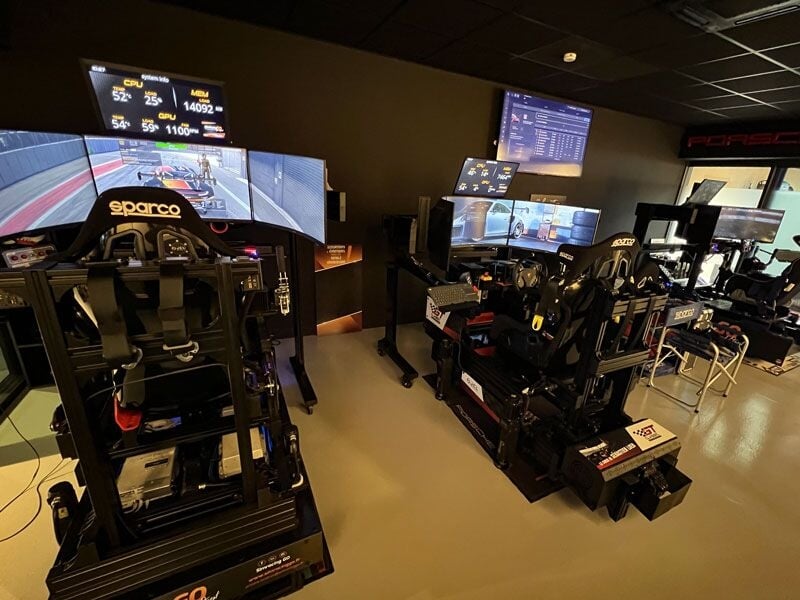 Salle avec plusieurs simulateurs de conduite automobile équipés de volants, sièges et écrans.