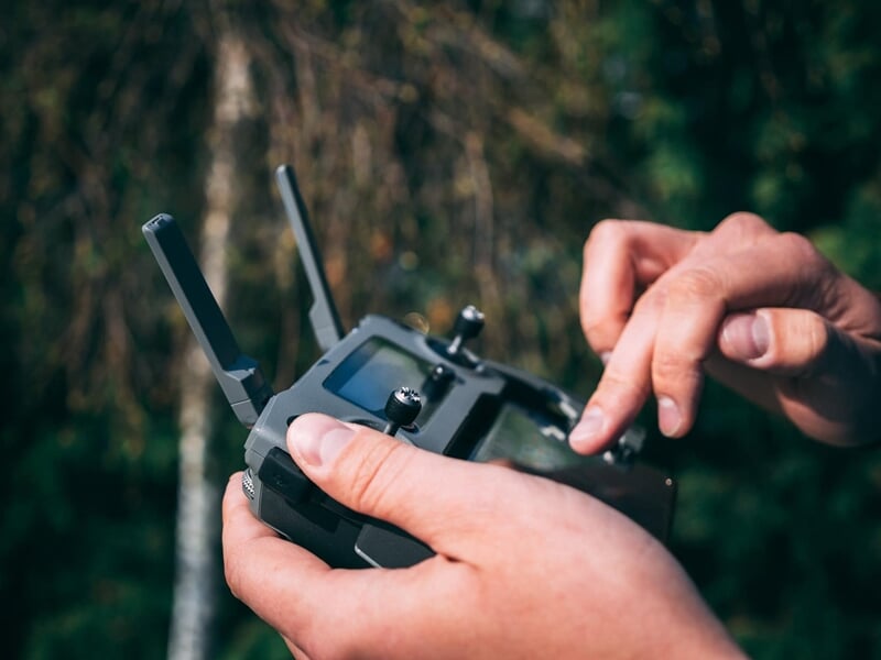 homme avec une téélcommande de drone en main