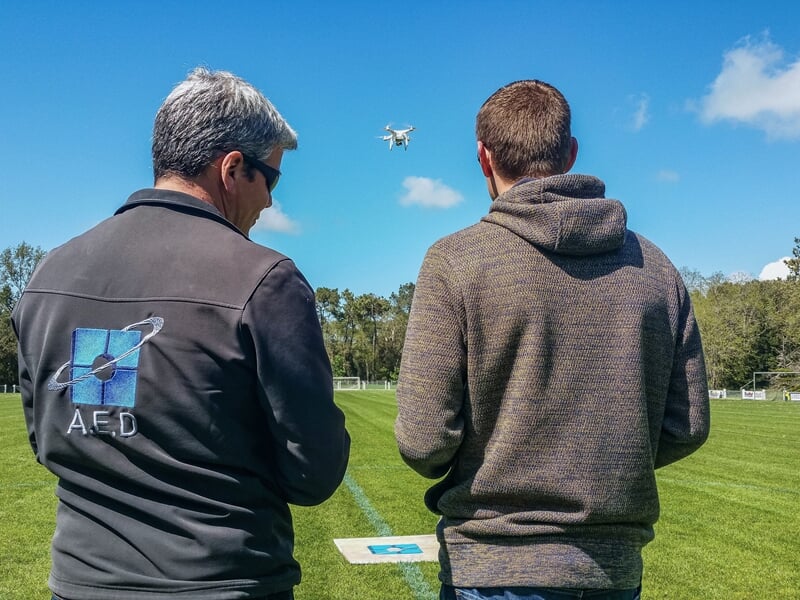 Deux hommes pilotant un drone