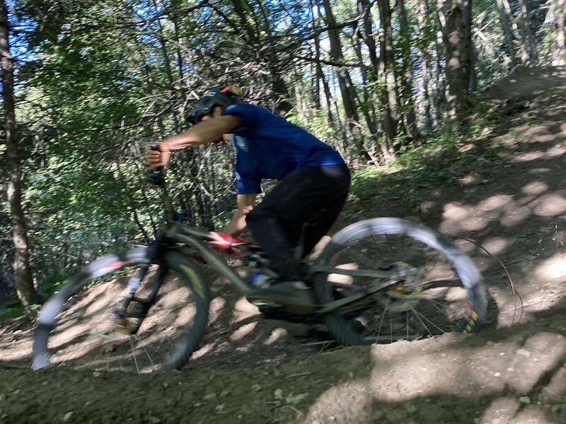 Homme pratiquant le VTT de descente en forêt