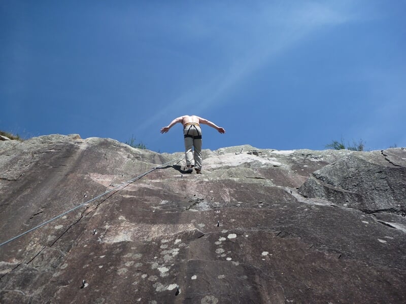 personne pratiquant la descente en rappel
