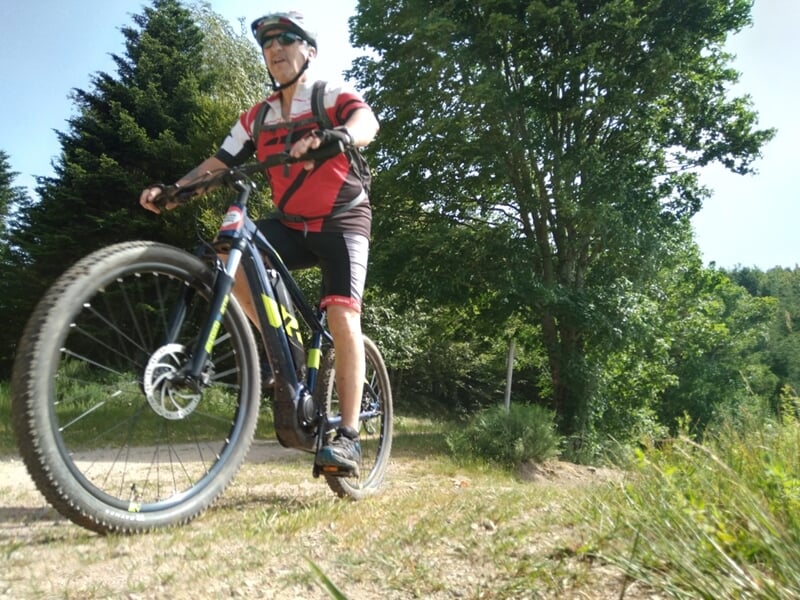Homme en train de rouler en vtt électrique sur chemin en campagne