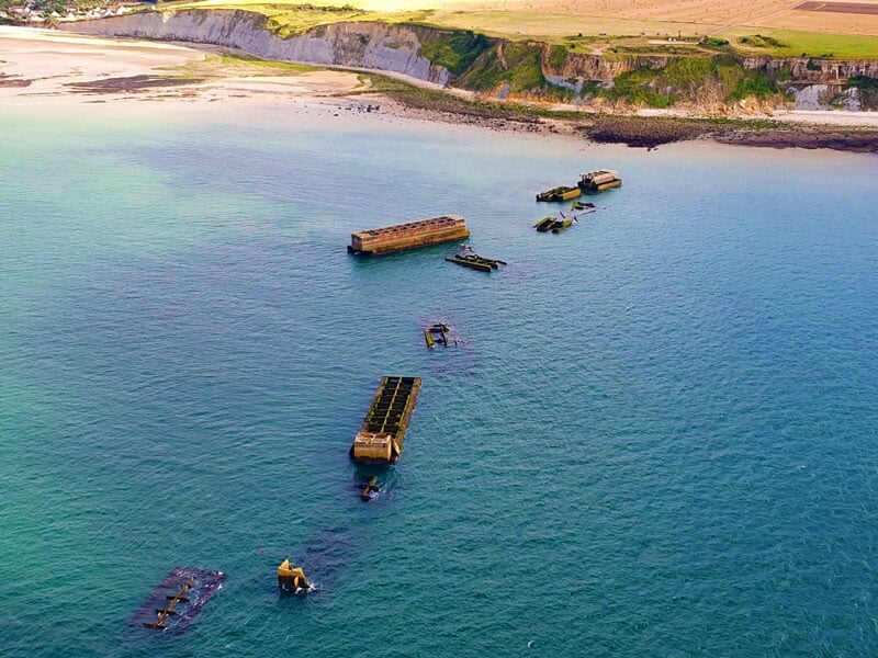 vue aérienne sur les vestiges du port artificiel d'arromanches dans la mer