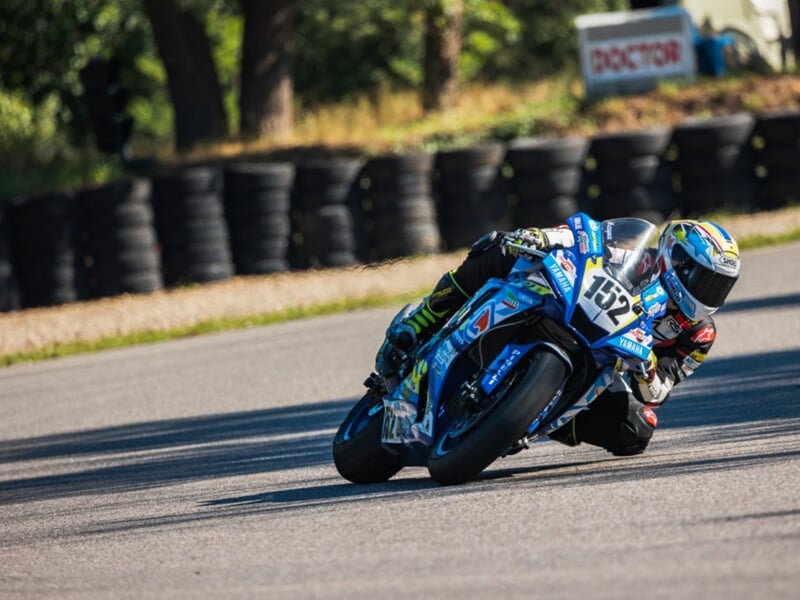 pilote de moto sur circuit en plein virage