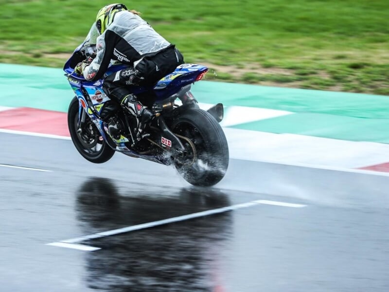 pilote de moto sur circuit avec route mouillée