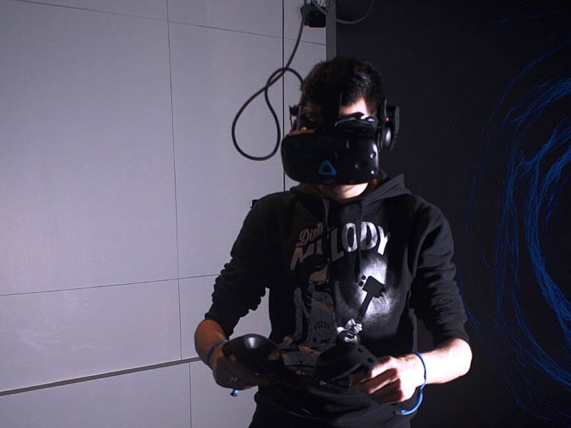 un homme joue en VR avec un casque HTC Vive Pro