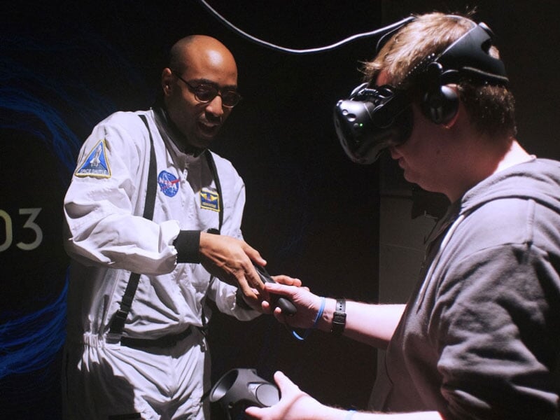 un moniteur du centre équipe un joueur de ses manettes VR