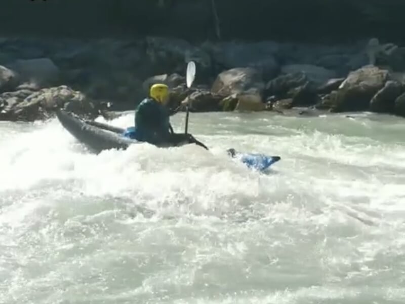 une personne dans un airboat dans les eaux vives en train de pagayer en descente dans la rivière proche de Briançon