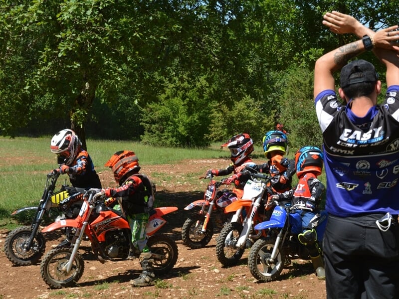Groupe d'enfants en mini moto sur chemin